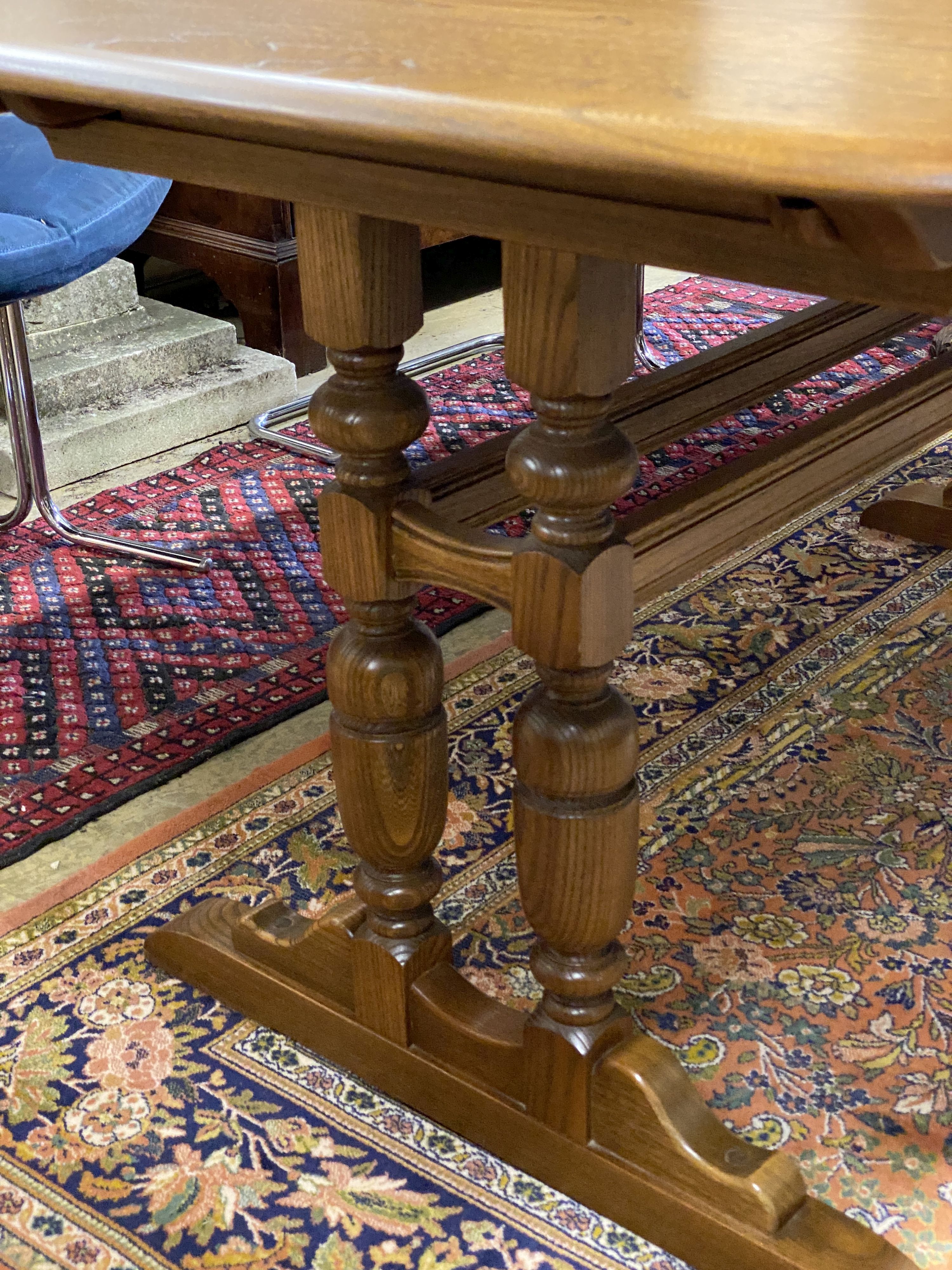 An Ercol Golden Dawn elm extending dining table, length 250cm extended (three spare leaves), width 100cm, height 74cm